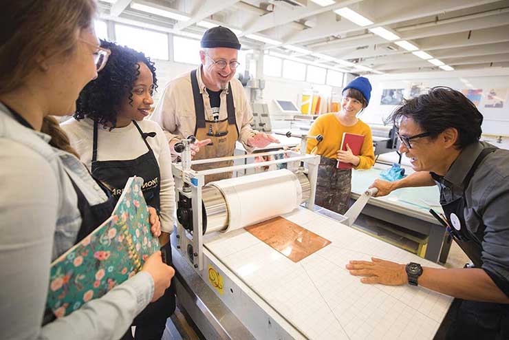 University of Tennessee printmaking class with students at a press.