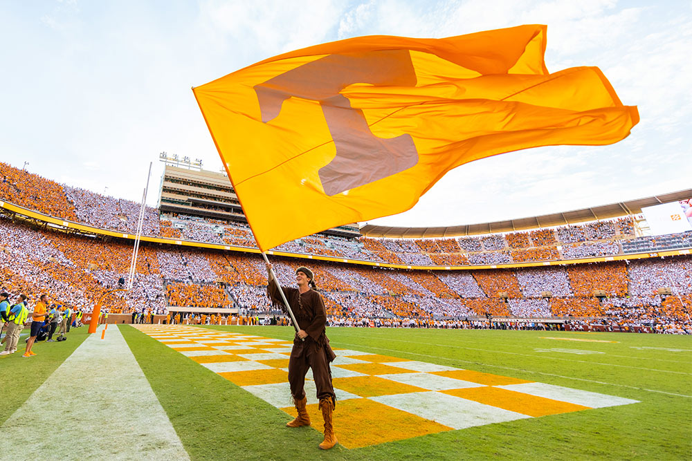 Man holding a Tennessee flag at a football game