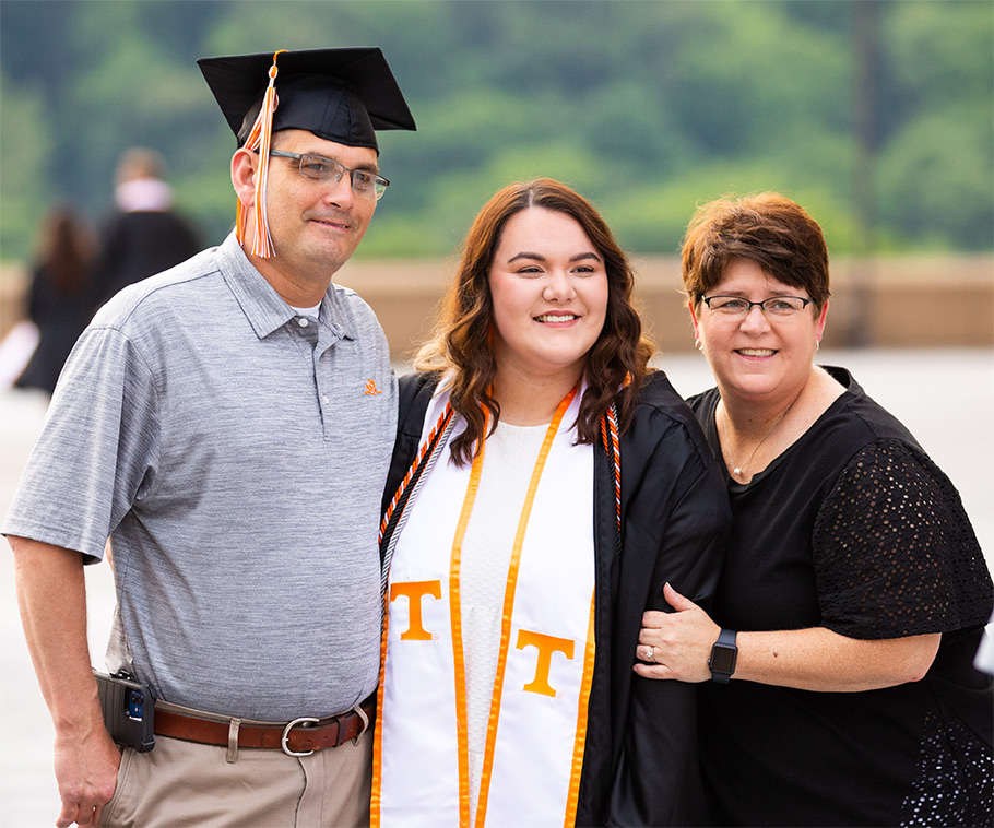 A family stand proudly next to their recent graduate.