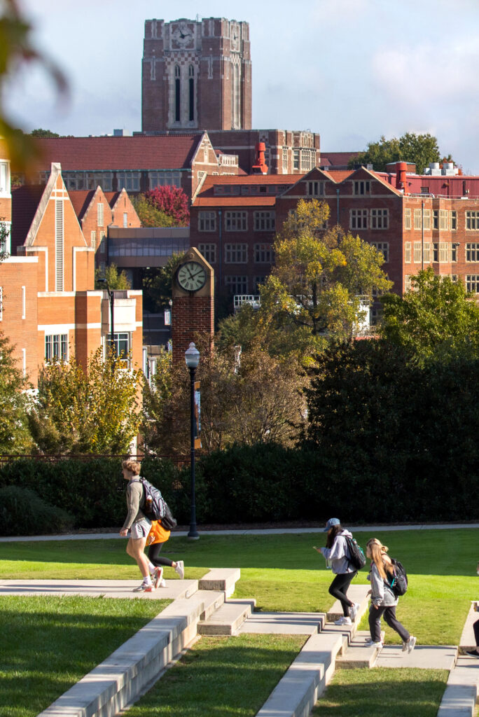 Students walk up the amphitheater steps located centrally on campus with Ayres Hall in the background.