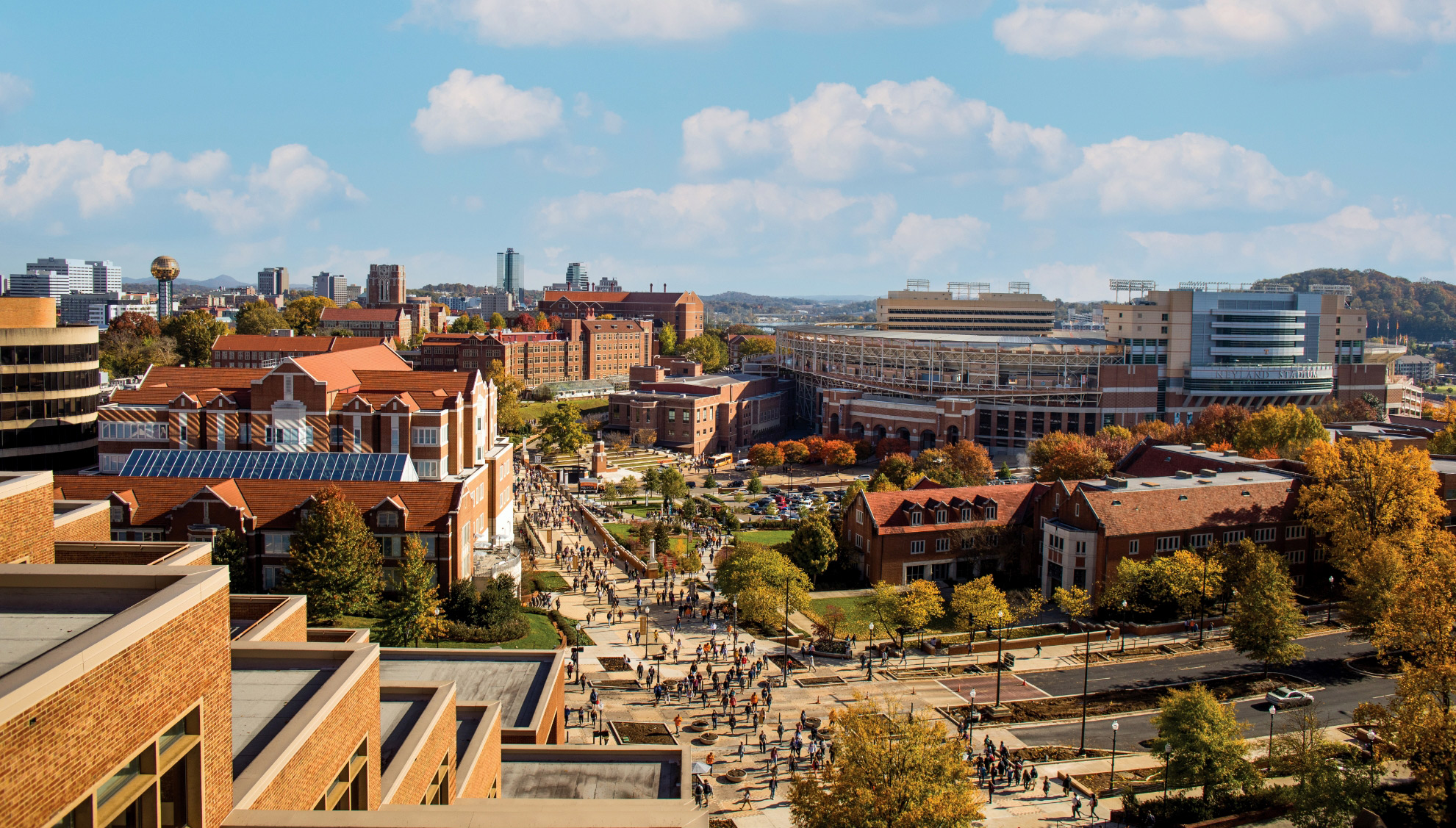 White puffy clouds float over campus on a beautiful day.