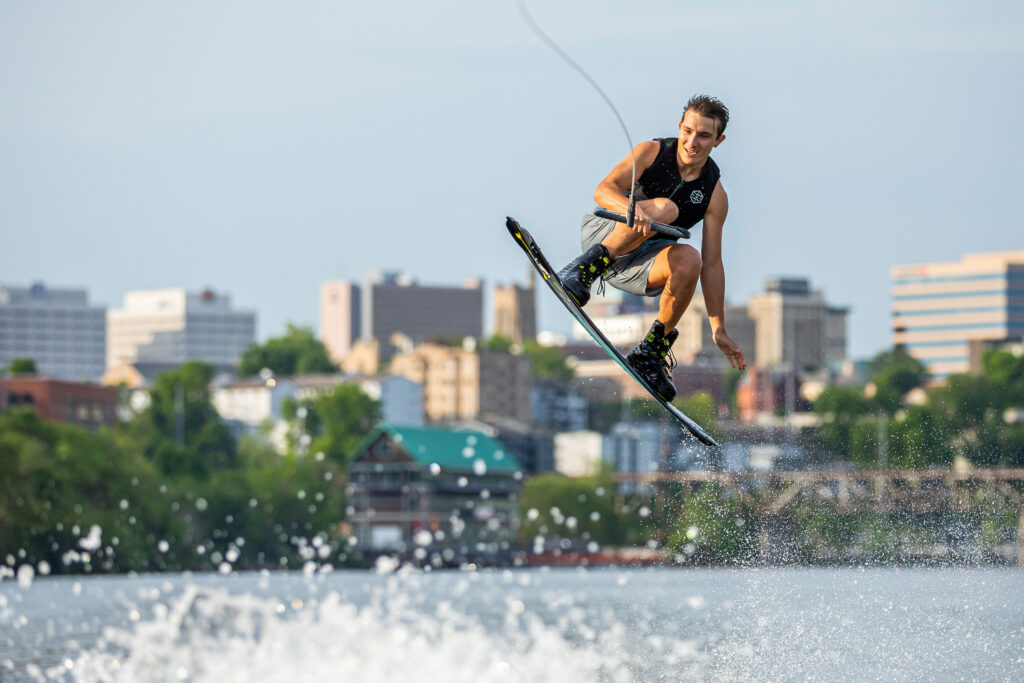 a single wakeboarder catches some air on the Tennessee River with the city visible in the distance
