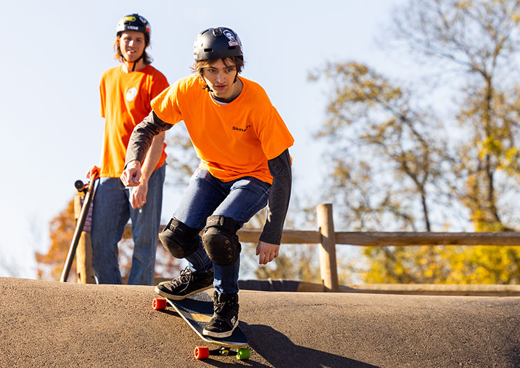 two skateboarders hit the pump track at Baker Creek Reserve