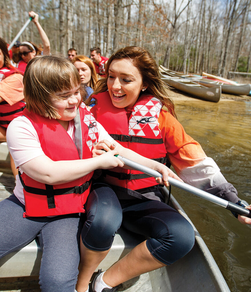 Student paddles in a canoe with a camper at Camp Koinonia
