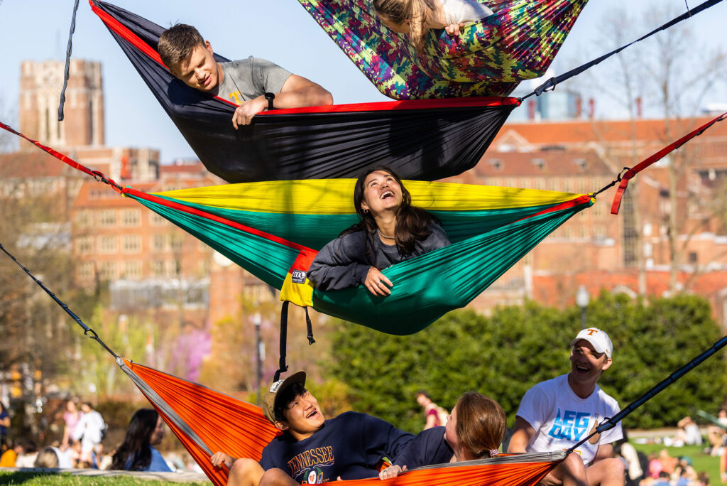 Students hang out in vertically stacked hammocks in the middle of campus