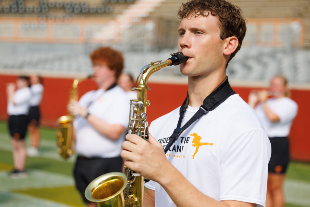 Saxophone players march on the field during a practice