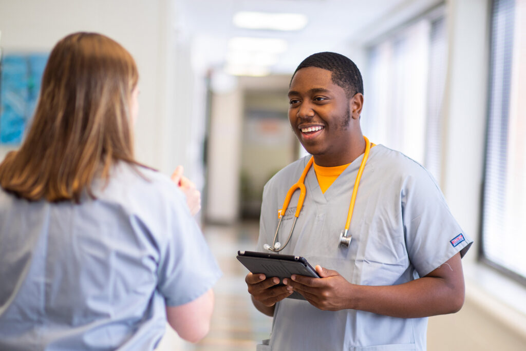 two medical workers discuss a patient in the hall