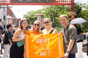 students stand with a flag in an Asian country