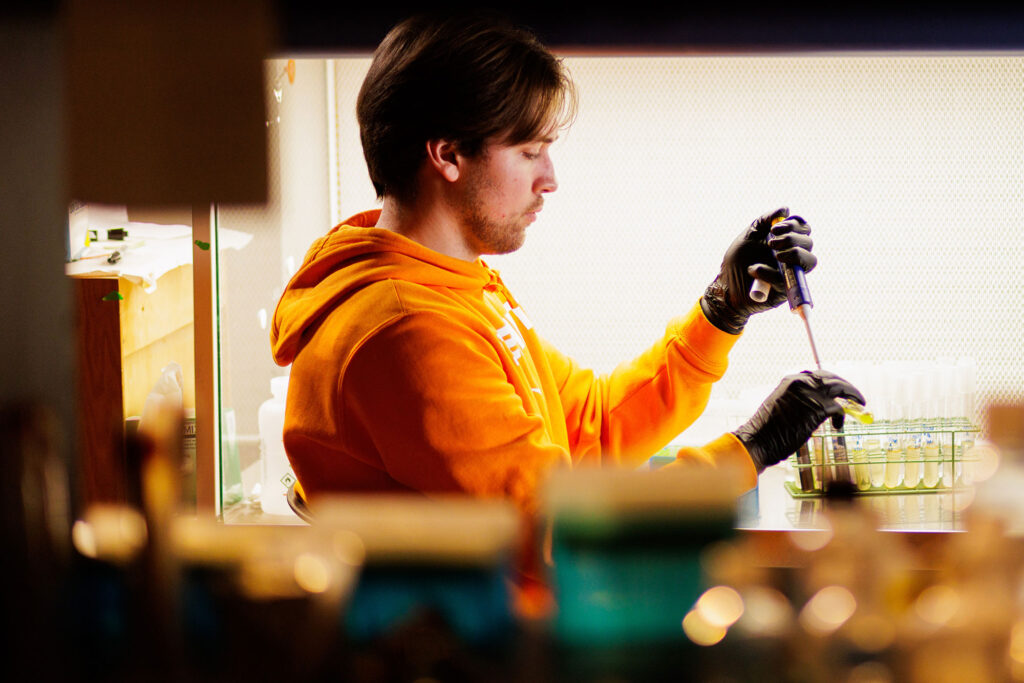 a microbiology student does detail work measuring liquids in a lab