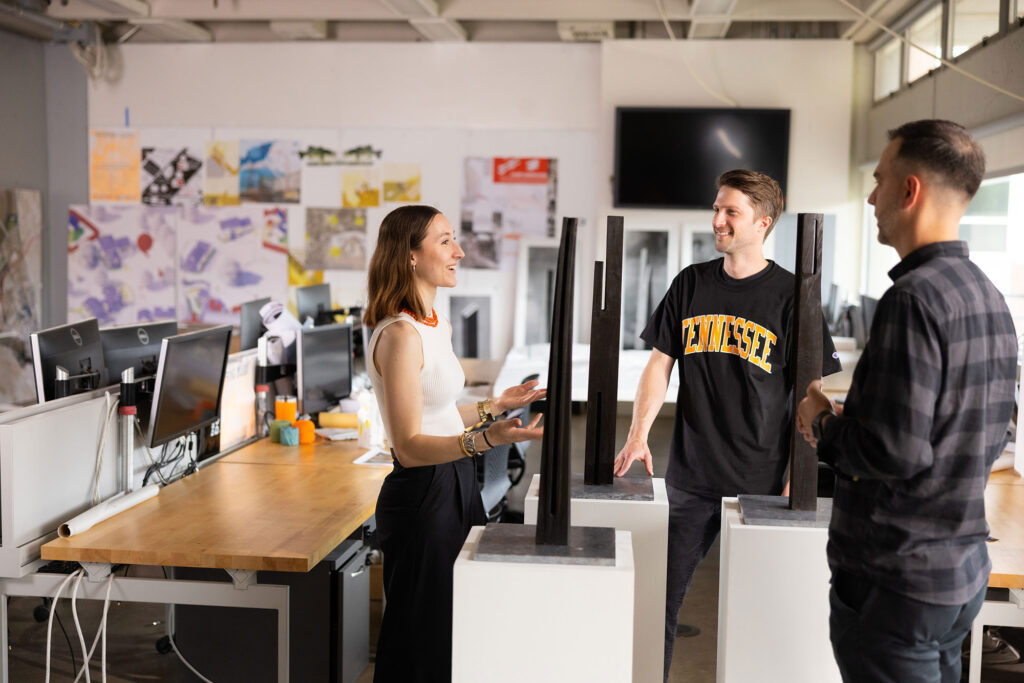 Architecture students have a discussion with a faculty member in an architecture classroom 